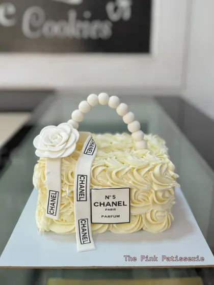 We designed this elegant cake to look just like a classic Chanel handbag. The delicate buttercream rosettes and edible pearl handle showcase our detailed piping and sculpting work for a sophisticated celebration.