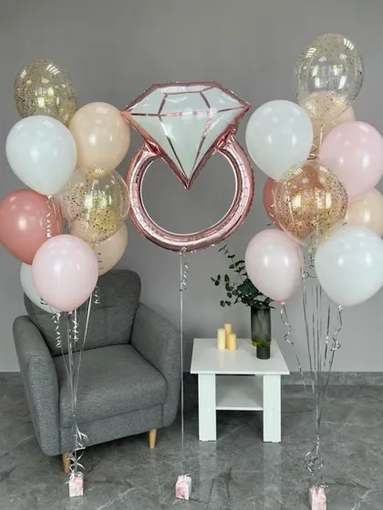 A perfect prop or centerpiece for a bridal shower. This balloon arrangement features a large diamond ring foil balloon surrounded by a bouquet of pastel and confetti balloons.