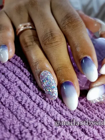 A beautiful purple-to-white ombre set, with two accent nails covered in holographic silver glitter for a dazzling effect.