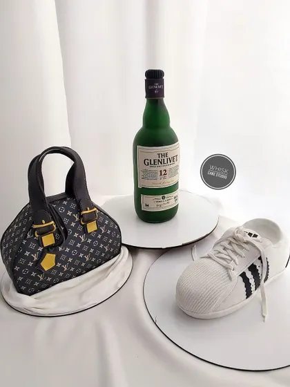 A showcase of our sculpted structure cakes. This image features three different designs: a Louis Vuitton bag, a Glenlivet bottle, and an Adidas sneaker, all fully edible.