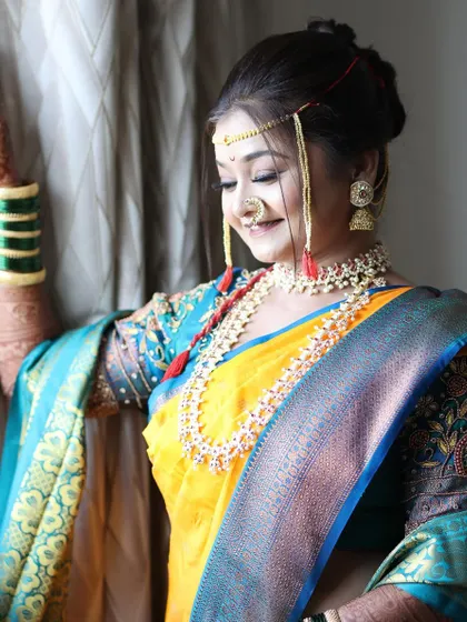 A beautiful candid shot of the bride by the window. The natural light illuminates her features and the subtle glow of her makeup, creating a timeless and elegant portrait.