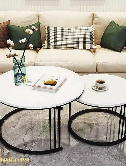A minimalist nesting table set with clean white tops and slender black metal bases. The design allows the smaller table to tuck neatly under the larger one, making it a smart solution for compact living areas.