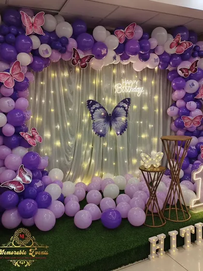 A close-up of the butterfly-themed first birthday setup, showing the fairy lights and butterfly accents.