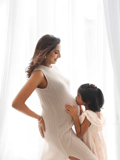 A daughter’s first bond with her new sibling. A sweet kiss on the baby bump is a beautiful way to include older children in your maternity photos, capturing their excitement and love.