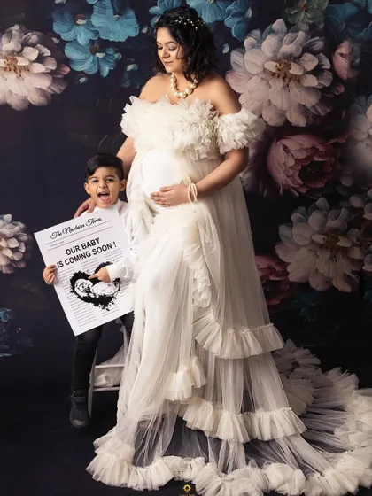 The expecting mother and her excited son share the spotlight. Her beautiful white ruffled gown is one of many options available for moms-to-be in my studio wardrobe.