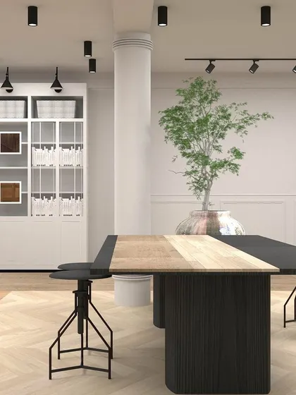 This render visualizes a central worktable and storage area in the retail space. The industrial-style stools and large display cabinet were key elements in the functional design.