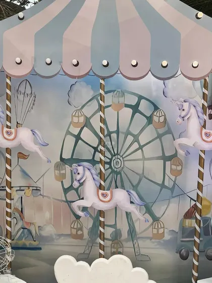 A close-up of the beautiful carousel backdrop, with unicorn ponies against a ferris wheel background.
