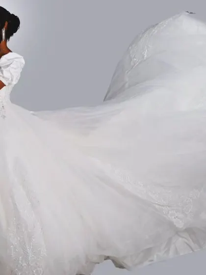 The drama of a flowing train. This shot captures the sheer volume and movement of one of my custom white ball gowns, designed to make a grand entrance.