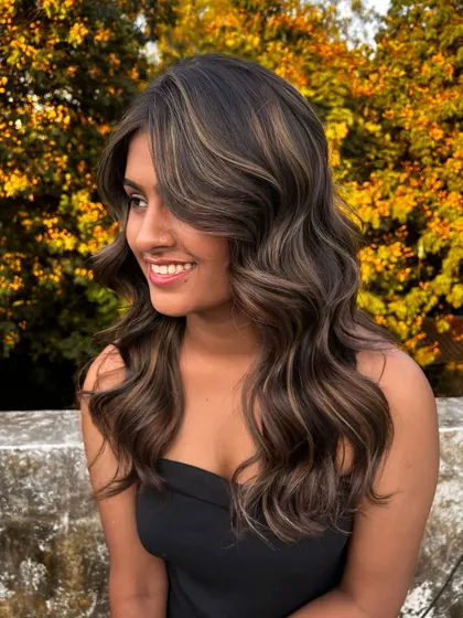 A beautiful shot of the balayage created during my Surat masterclass, with the warm tones of the hair complementing the autumn-colored background.