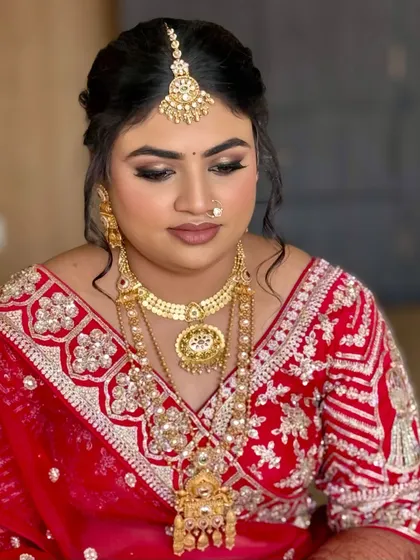 A close-up of the bride's glamorous red bridal look. The smoky eye and perfectly sculpted brows add a touch of drama, while the skin remains radiant.