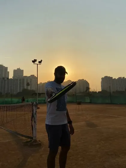 A silhouette of our coach against the sunset. This image captures our passion for the game, a dedication that we bring to the court every single day.