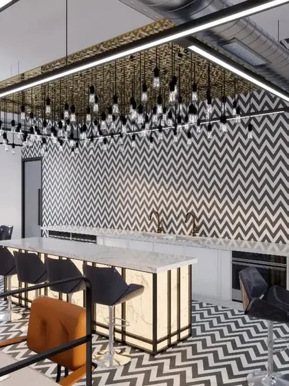 The stylish pantry and community area at KCC Works. We used bold geometric patterns on the floor and backsplash, along with a dramatic cluster of pendant lights, to create a vibrant social hub.