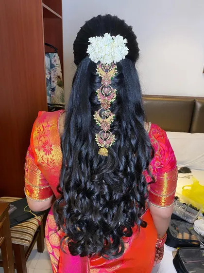 A half-updo with dramatic curls, featuring a traditional jada set placed vertically for a unique and modern twist.