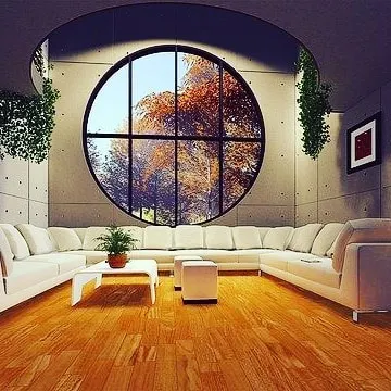 A grand living room with a large circular window, where the neutral wall color allows the architecture and view to be the main focus. My job is to provide a perfect canvas.