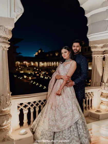A stunning portrait of the couple during their engagement at Rambagh Palace, with the illuminated courtyard creating a magical backdrop.