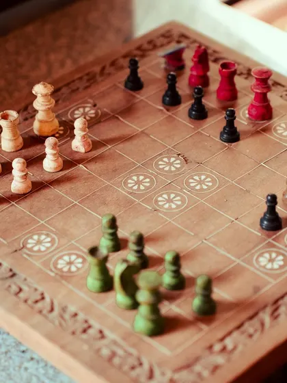 The colorful, hand-painted chess pieces add a touch of rustic charm to the game.