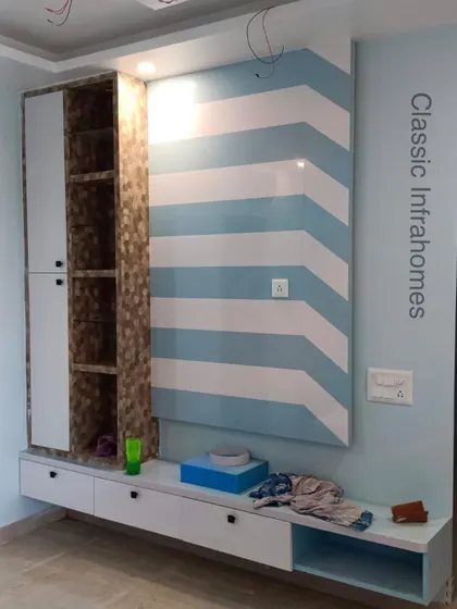 This TV unit from our Kendriya Vihar project features a bold, chevron-patterned back panel in blue and white. The unit includes both open and closed storage for a balanced look.