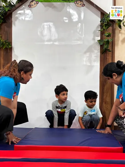 Our instructors are right there on the floor with the children, guiding and encouraging them. Here, we are setting up a soft gymnastics mat, ensuring a safe and supportive space for them to practice their coordination and balance.