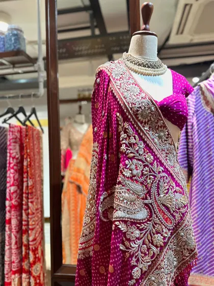 A heavily embroidered saree perfect for a bride or a wedding guest. The intricate silver work on the fuchsia bandhani fabric is a testament to incredible craftsmanship.