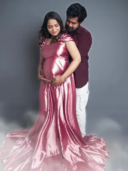 A dreamy couple's portrait with a soft fog effect at the bottom. The shiny pink gown and the loving embrace create a romantic and magical atmosphere.