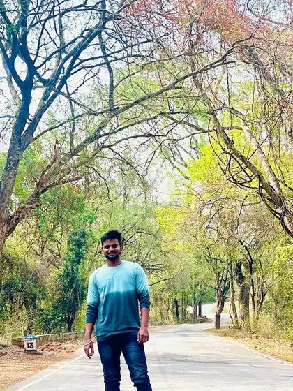 Standing on the road surrounded by the beautiful trees on the way to Hogenakkal.