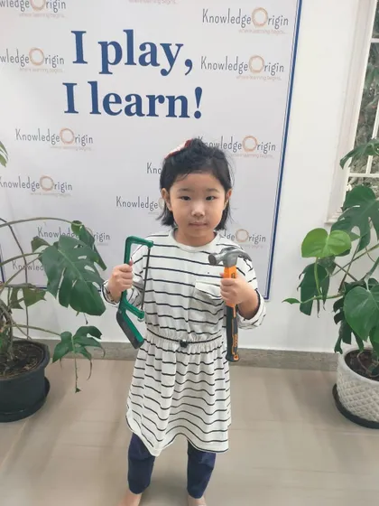 A young girl holds her tools, ready for the next challenge. My camps are designed to foster independence and a can-do attitude in every child.