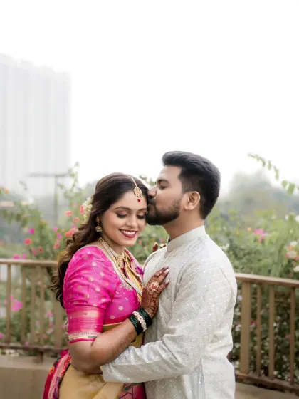 A tender moment captured during a couple's portrait session, with the groom placing a gentle kiss on the bride's forehead.