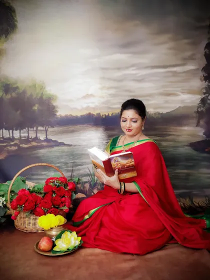 A duplicate of image 120, this traditional portrait captures a quiet moment of a mom-to-be reading in a beautiful saree.