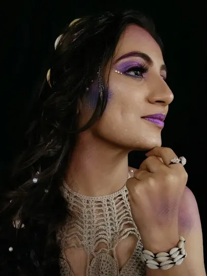A profile view of the mermaid makeup, showing the shell headband and the glitter details in the hair.