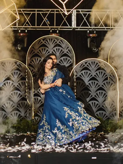 A stunning twirl in a beautiful blue lehenga against a dramatic stage setup. We help you create these breathtaking visuals for your wedding film.