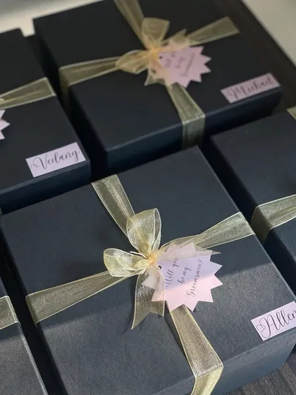 All packed and ready to go! These black groomsmen boxes are finished with a gold ribbon and a personalized name tag for that final elegant touch.