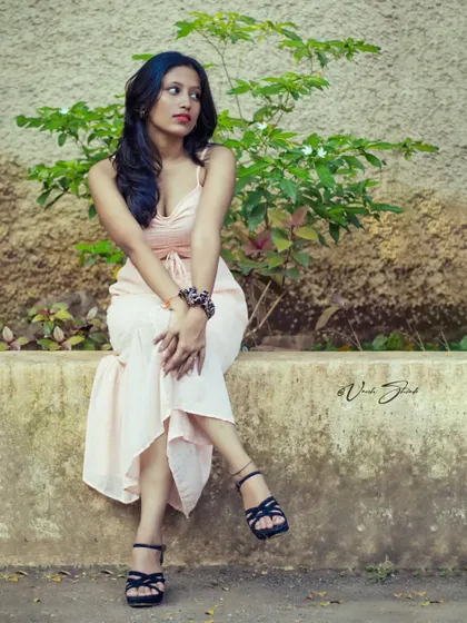 A full-body lifestyle shot showing the model in a relaxed, seated pose. This helps to show how a model carries themselves in a more casual, natural setting.