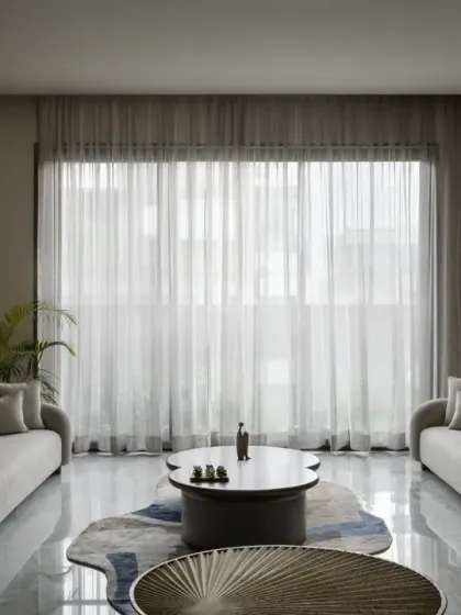 The drawing room of The House of Dancing Screens features a unique wall painting crafted from an assortment of natural stones. This abstract piece serves as an elegant focal point against the warm, wood-paneled wall.
