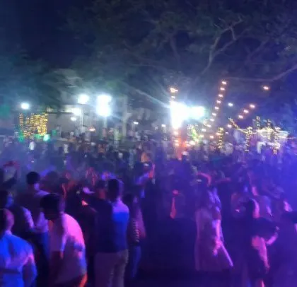 A massive outdoor corporate Holi party for over 2,000 people. The lighting setup covers a large area, ensuring the party vibe extends to everyone.