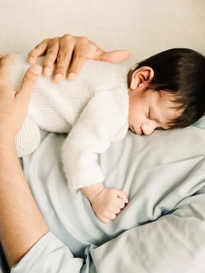 A beautiful shot of a newborn sleeping peacefully on their father's chest, a moment of pure trust and comfort.