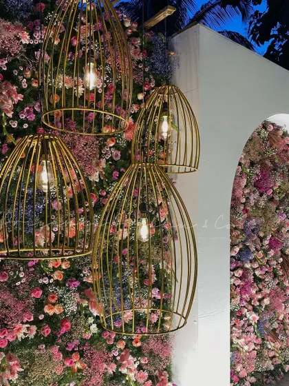A detail shot of the reception stage decor. The combination of a dense wall of pink and lilac flowers with the warm light from the golden birdcage chandeliers created such an exquisite texture.