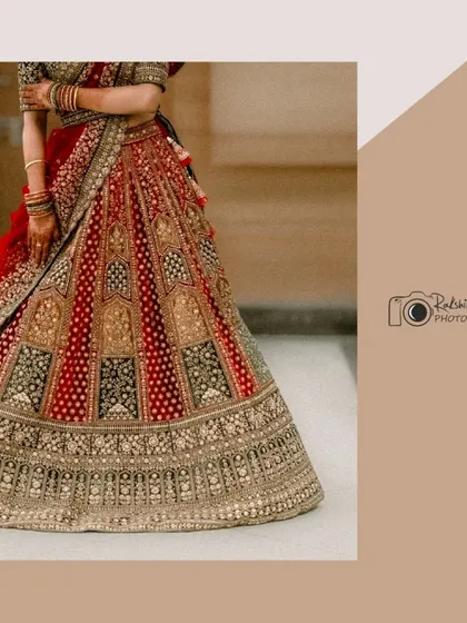 A detail shot focusing on the bride's magnificent red and gold lehenga. This artistic composition highlights the incredible craftsmanship and grandeur of her wedding attire.