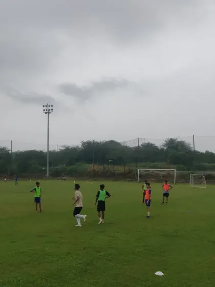 A view of the training ground with players spread out, engaged in various activities.