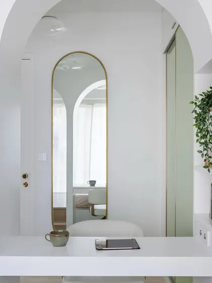 A detail shot of the arched mirror and minimalist desk in the teen's room, reflecting the seamless flow and clever use of space.