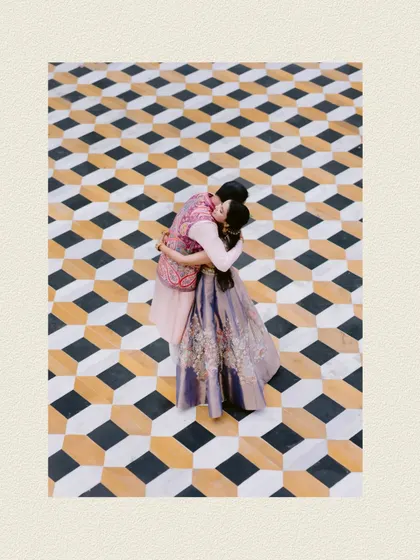 A stunning top-down drone shot of the couple sharing a kiss on a mesmerizing 3D-effect tiled floor in Udaipur, a truly unique and artistic wedding portrait.