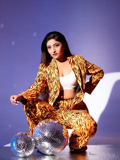 A trendy pose with our tiger-print suit and disco ball props, creating a fun, retro-glam vibe.