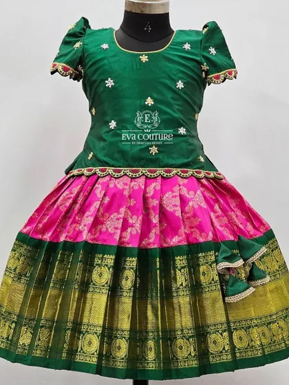 A mannequin view of the pure Kanchi pattu lehenga in green and pink. This showcases the scalloped peplum top and the beautiful drape of the silk skirt.