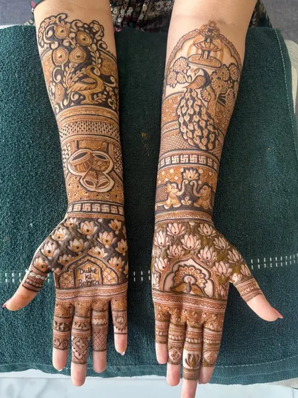 A beautiful and complex bridal design, combining peacocks, elephants, wedding rings, and lotus motifs.