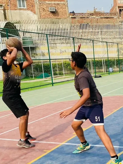 A player practices their shooting form against a defender, learning to shoot under pressure.