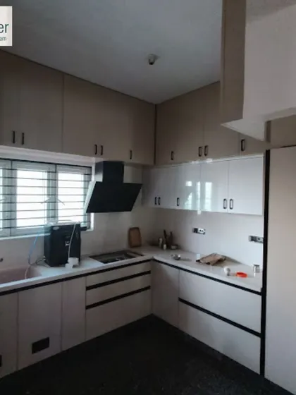 This kitchen features two-tone cabinets and freshly painted walls. A professional paint job is key to achieving a high-end look in a kitchen renovation.
