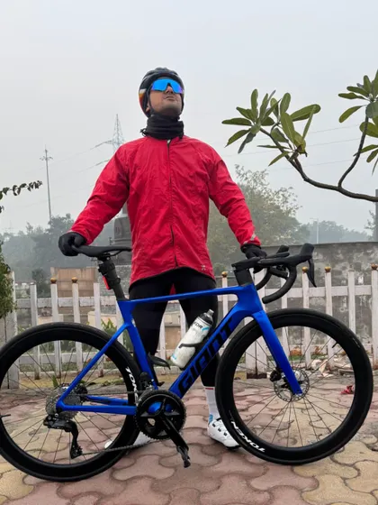 A rider in a red jacket with his stunning blue Giant bike, ready for a chilly Christmas morning ride.