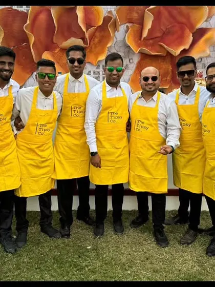 Our team in their signature bright yellow aprons, lined up and ready for an outdoor event. This uniform is perfect for sunny, cheerful celebrations like brunches and mehendis.