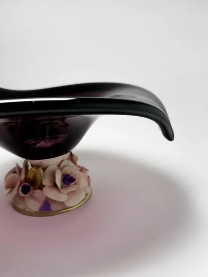 A side view highlighting the elegant curve of the amethyst Murano bowl and the intricate detail of its floral base. It is a piece that is beautiful from every single angle.