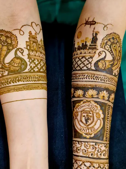 This design tells an international love story, from India to the USA. It includes the New York skyline with the Statue of Liberty, a Manchester United logo for the groom, and Indian motifs like the cobra and peacock.