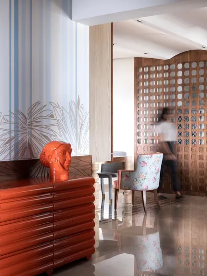 The wallpaper paired with a bold orange console, showcasing a playful mix of color and pattern.
